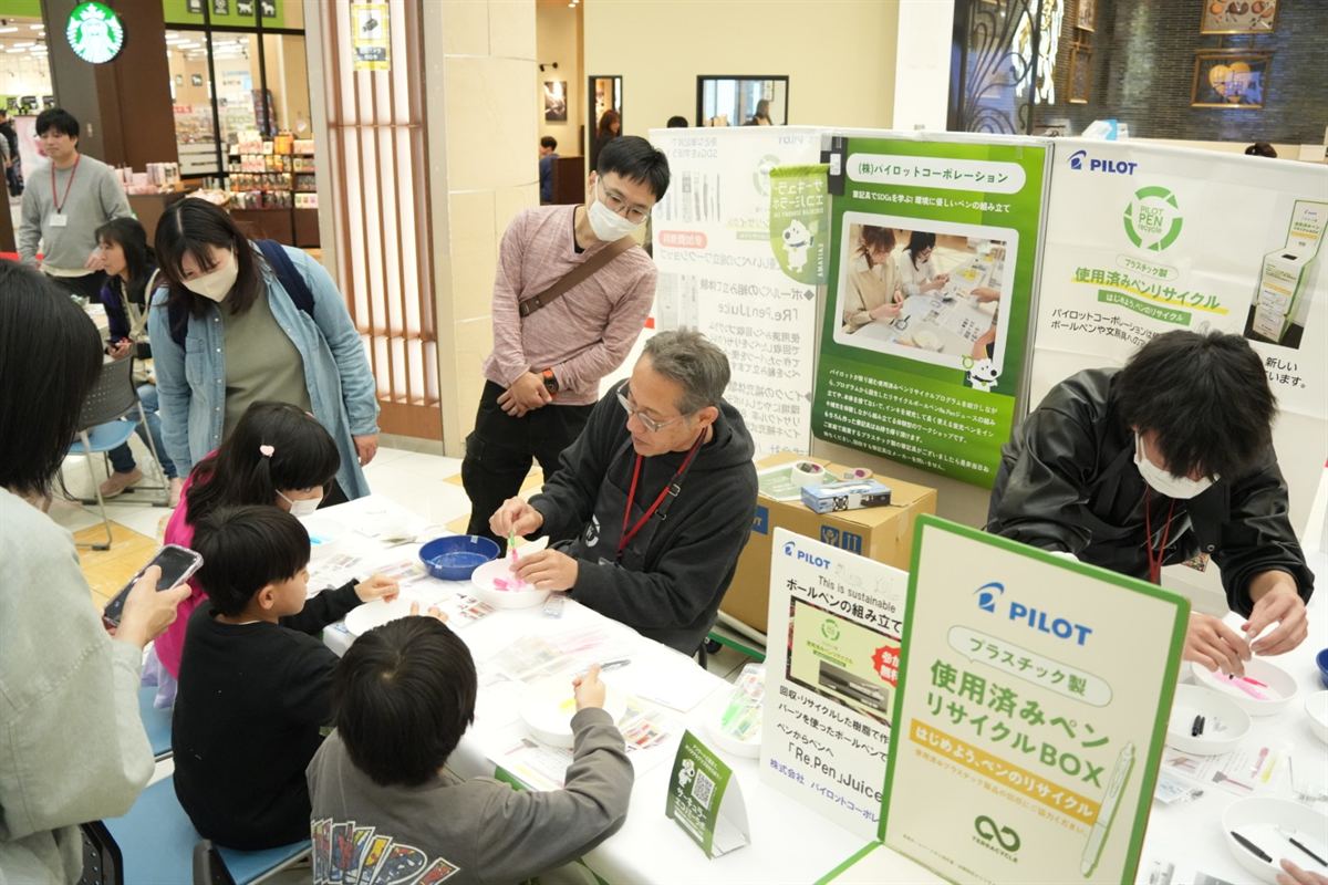パイロットのブースでペンの組み立てに取り組む来場者